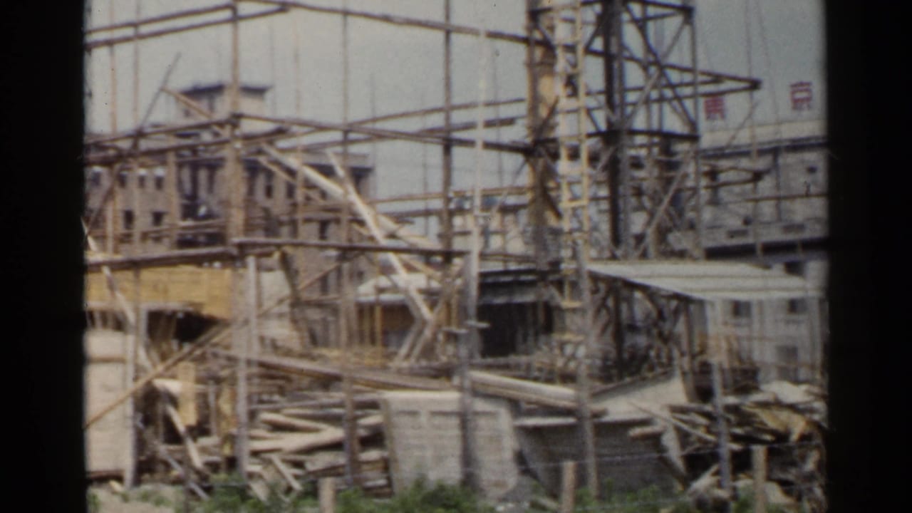 Construction site with wooden scaffolding around a multi-story building.