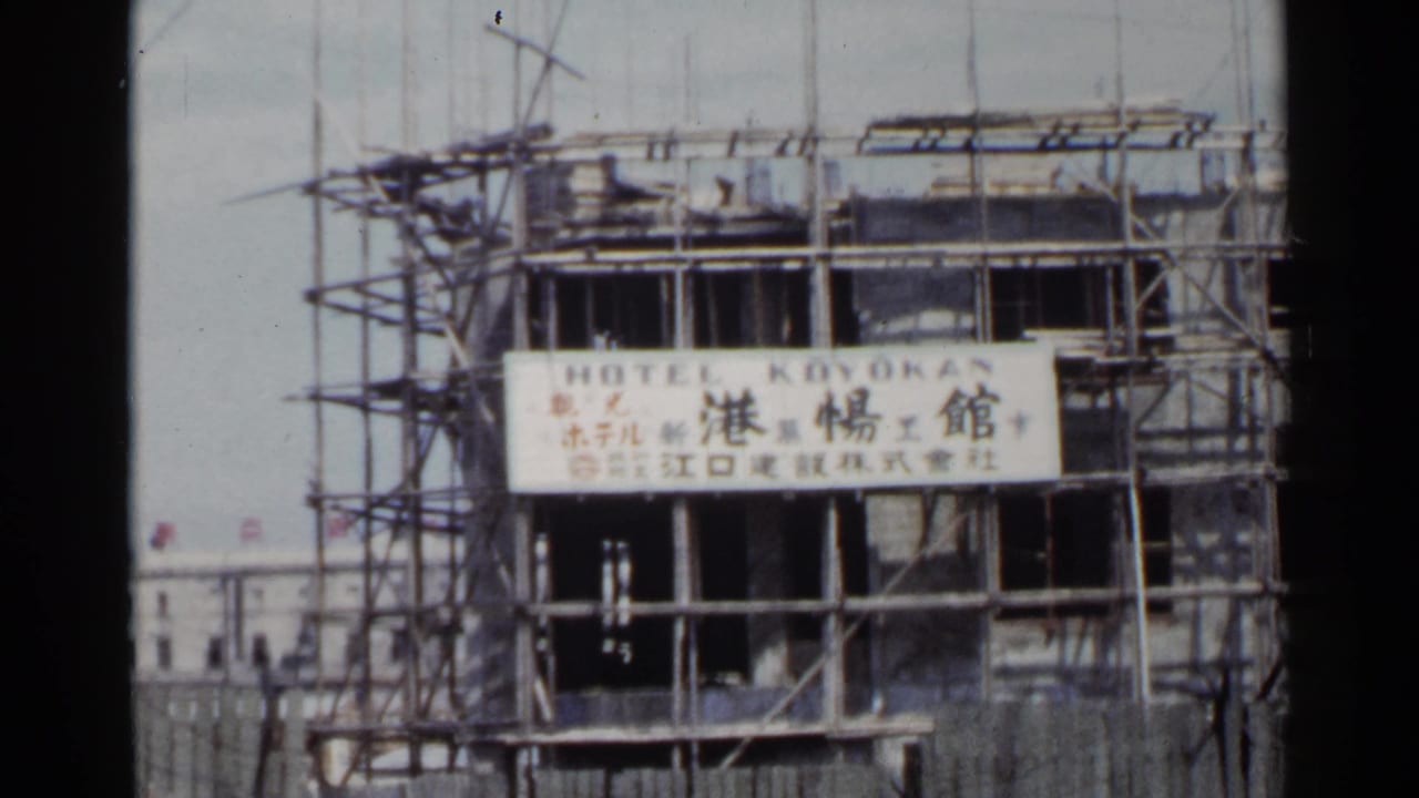 1953 Japan 8mm frame showing a hotel building under construction with scaffolding and a bilingual Hotel Koyokan sign.