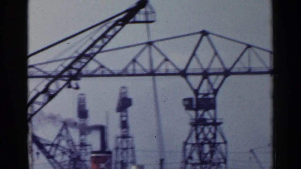 1953 Japan harbor view with a large gantry crane, angled crane boom, and distant industrial equipment.