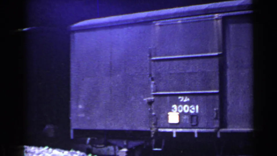 Close 1953 Japan rail-yard view of a dark freight car end with the painted number 30031 visible on the side.
