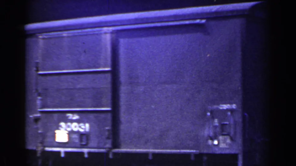 1953 Japan 8mm frame with a close, soft-focus view of a dark freight car side and the number 30031 near the lower left.