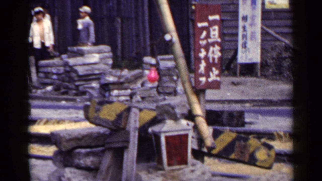 Road construction area with sandbags, barriers, workers, and Japanese signage.