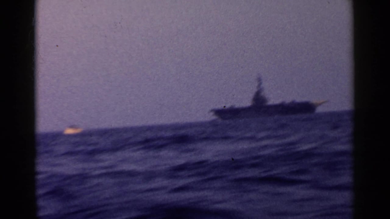 Distant ship on choppy ocean under a hazy sky.