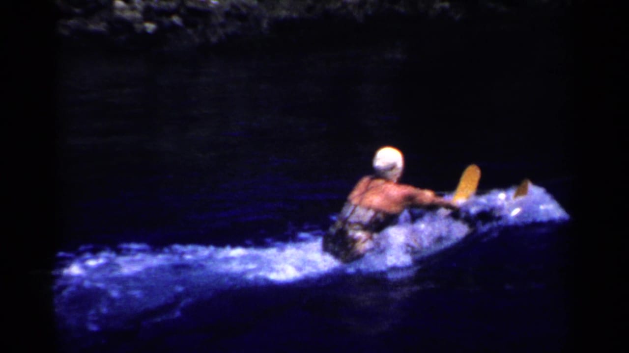 Water skier turns across dark water with spray behind her.
