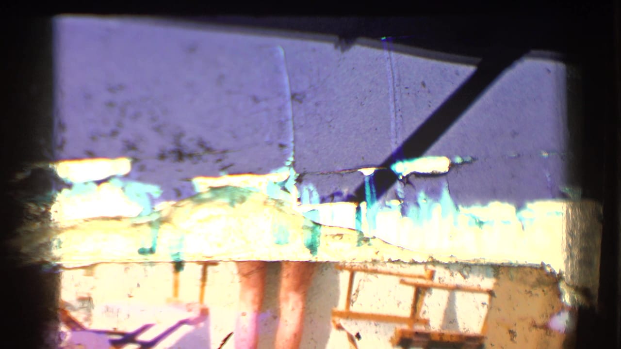 Overexposed 8mm frame with partial resort structures and film gate edges.