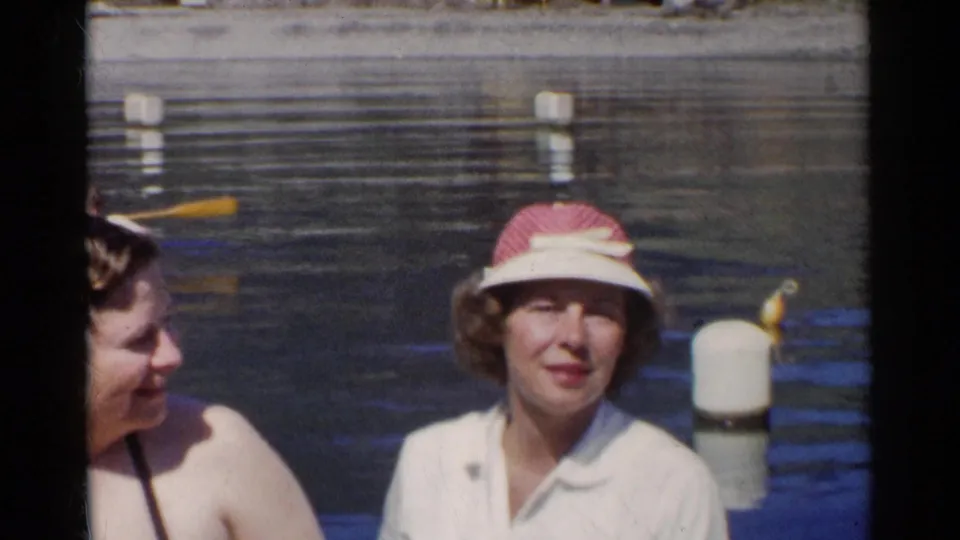 A tighter 1950s California lake frame shows two women near the water, including one in a red-and-white visor.