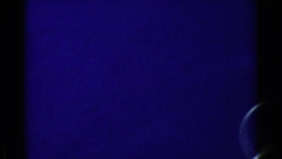 Blue 8mm frame from the California boat scene, with a partial passenger head or ear visible along the right border.