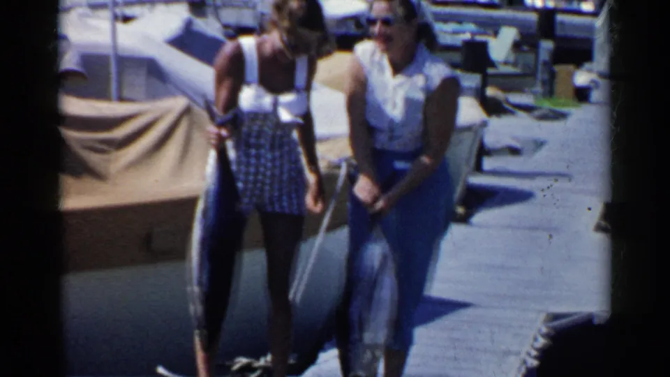 The final frame shows two adult women on a California dock holding large fish, with a boat and deck fittings visible behind them.