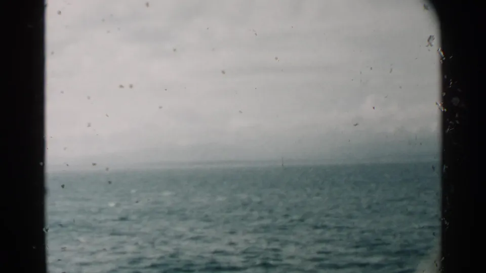 Pearl Harbor, Hawaii 1958 footage looking across rippled ocean water from inside or beside a moving vessel window.