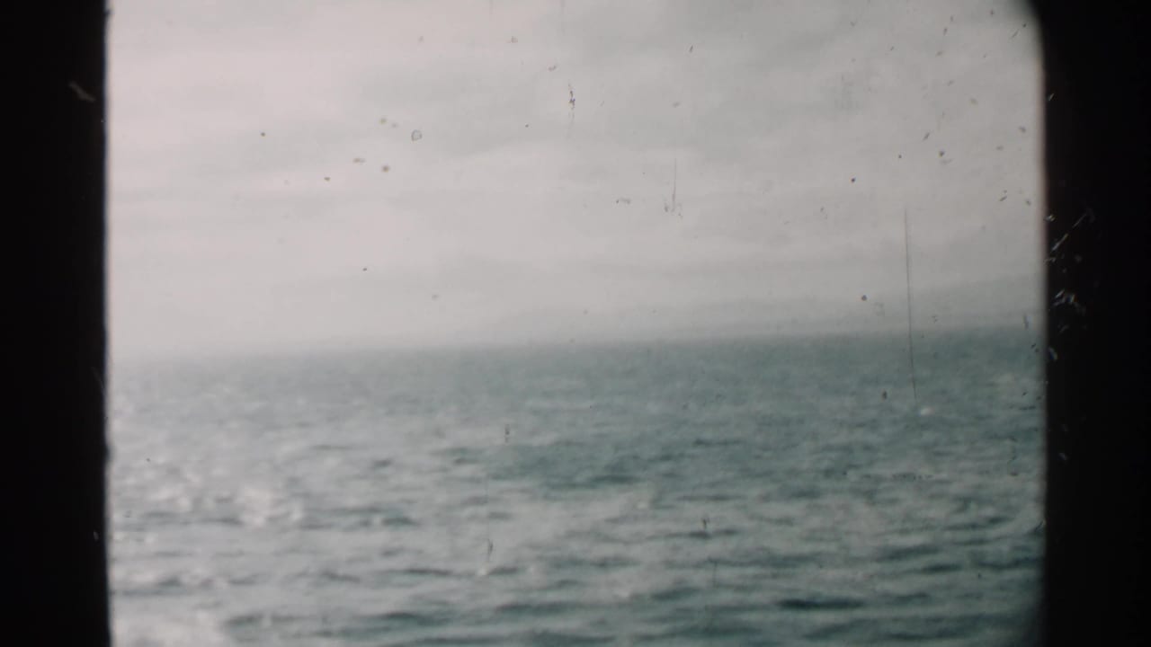 Gray ocean horizon seen through dark ship window edges.