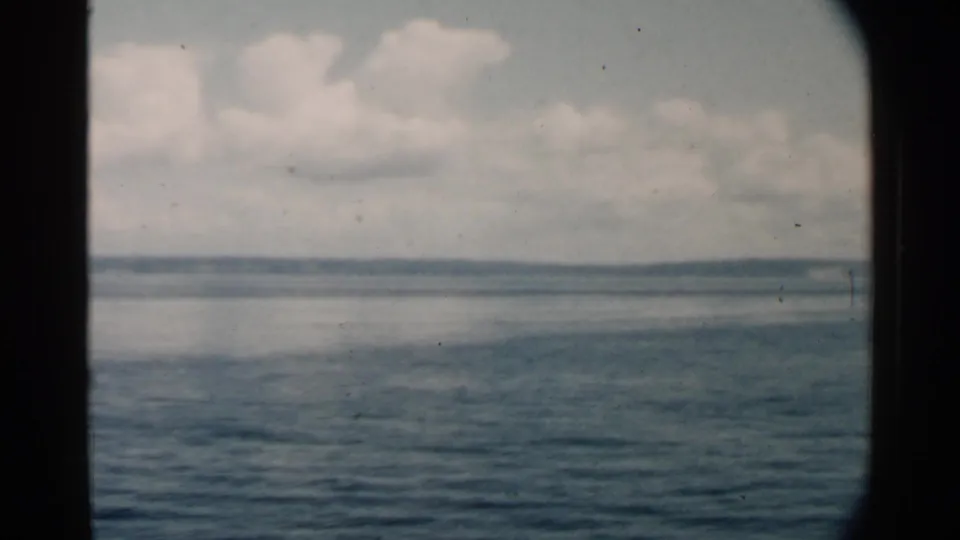 Pearl Harbor, Hawaii metadata frame with calm water, distant horizon, and cloud cover, bordered by dark vessel-window edges.