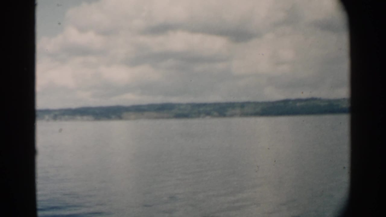 Open water and distant shore seen through rounded 8mm frame edges.