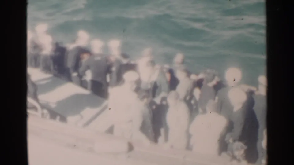 Final 1958 Pearl Harbor frame showing Navy personnel crowded on a small boat, with railings, deck surfaces, and rough water visible.