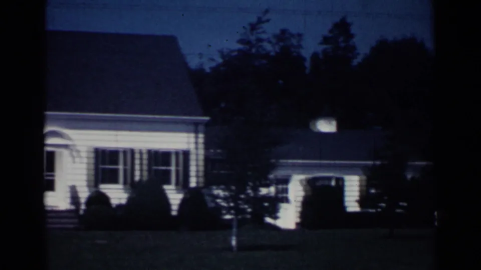 The final frame shows the Ohio suburban house and a garage or side building across the lawn, with trees and deep shadow in the 8mm exposure.