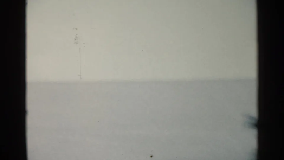 Final blurred frame from the 1959 San Francisco-area clip, showing a pale water or sky field, faint horizon, film marks, and dark edge bars.