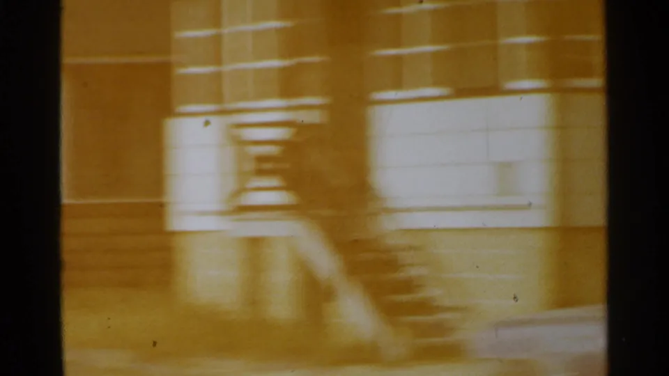 1959 San Francisco 8mm frame with a blurred building facade, stairs, and strong warm color shift as the camera moves.