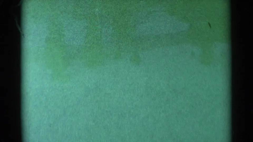 1959 South Dakota 8mm frame showing a dark vertical divider, green-blue fading, scratches, dust, and uneven exposure.