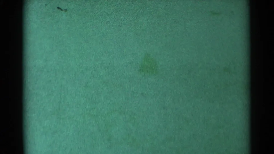 The 1959 South Dakota frame is largely abstract, with green film texture, a dark vertical edge and faint marks but no visible sledding action.