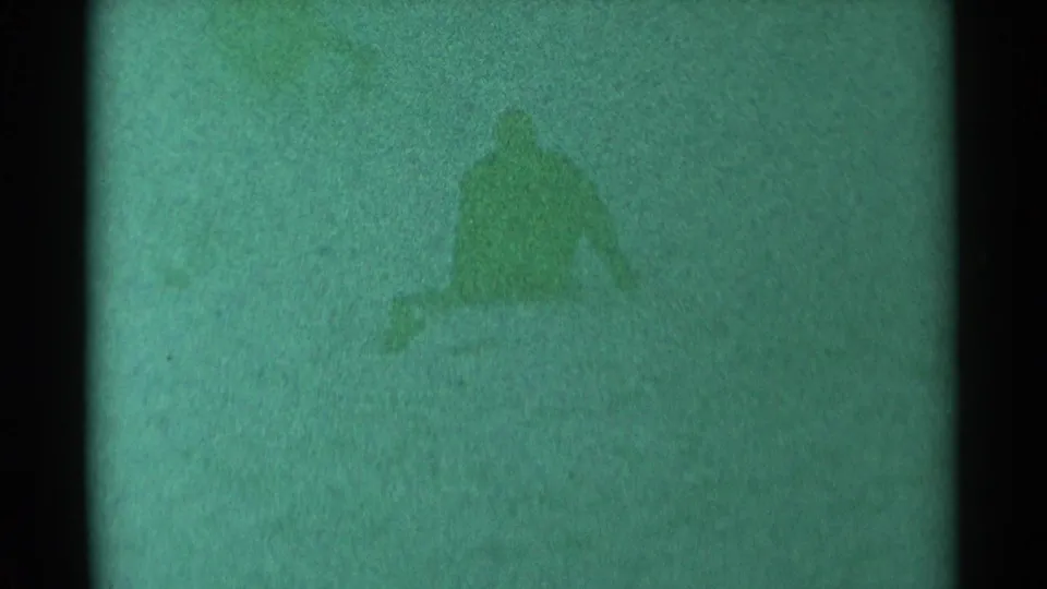 The sledder appears partly upright on the snowy slope, with the 1959 South Dakota scene softened by grain and color shift.
