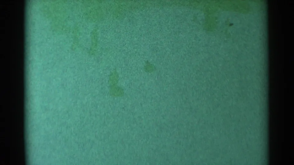 Distant figures remain visible on a grainy green-tinted South Dakota snow slope.