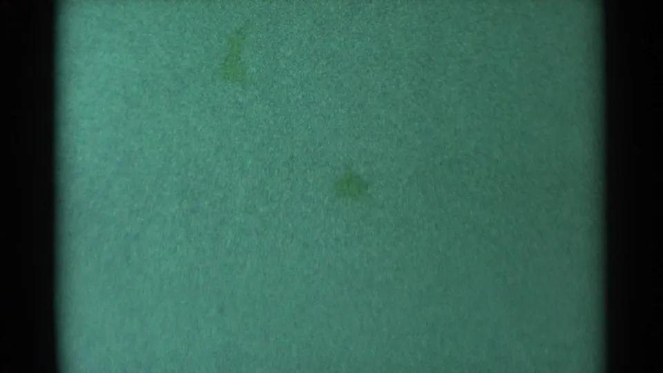 Faded 1959 South Dakota 8mm view of water, mostly abstracted by grain, green color shift, and vertical frame intrusion.