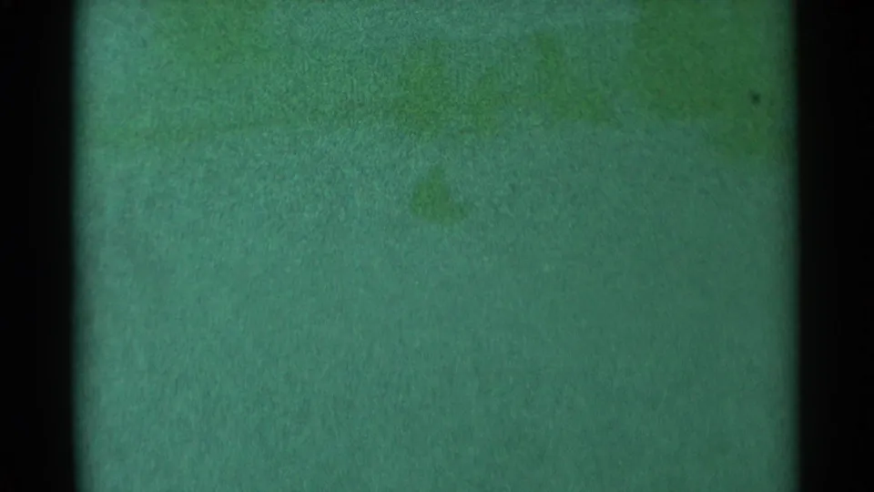 1959 South Dakota 8mm frame dominated by green-tinted film grain, dark border areas, and subtle exposure variation with no identifiable subject.