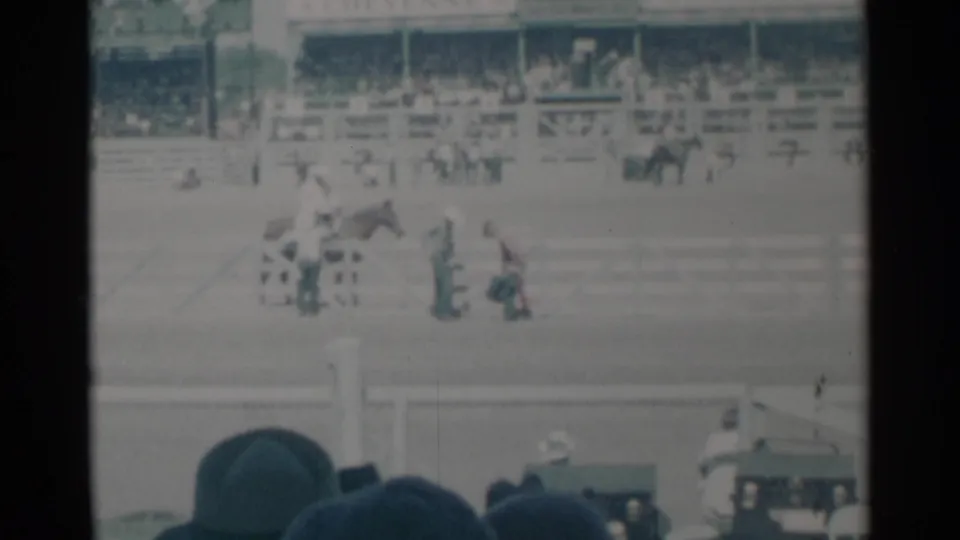 1960 Cheyenne rodeo footage shows a horse and people in the arena while spectators watch from grandstands behind them.