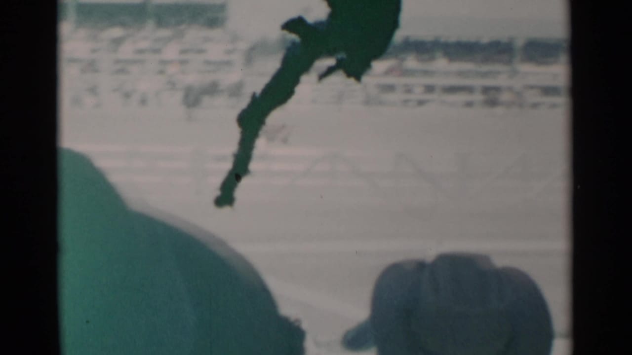 A cowboy-hat silhouette appears in the foreground as spectators look toward the arena.