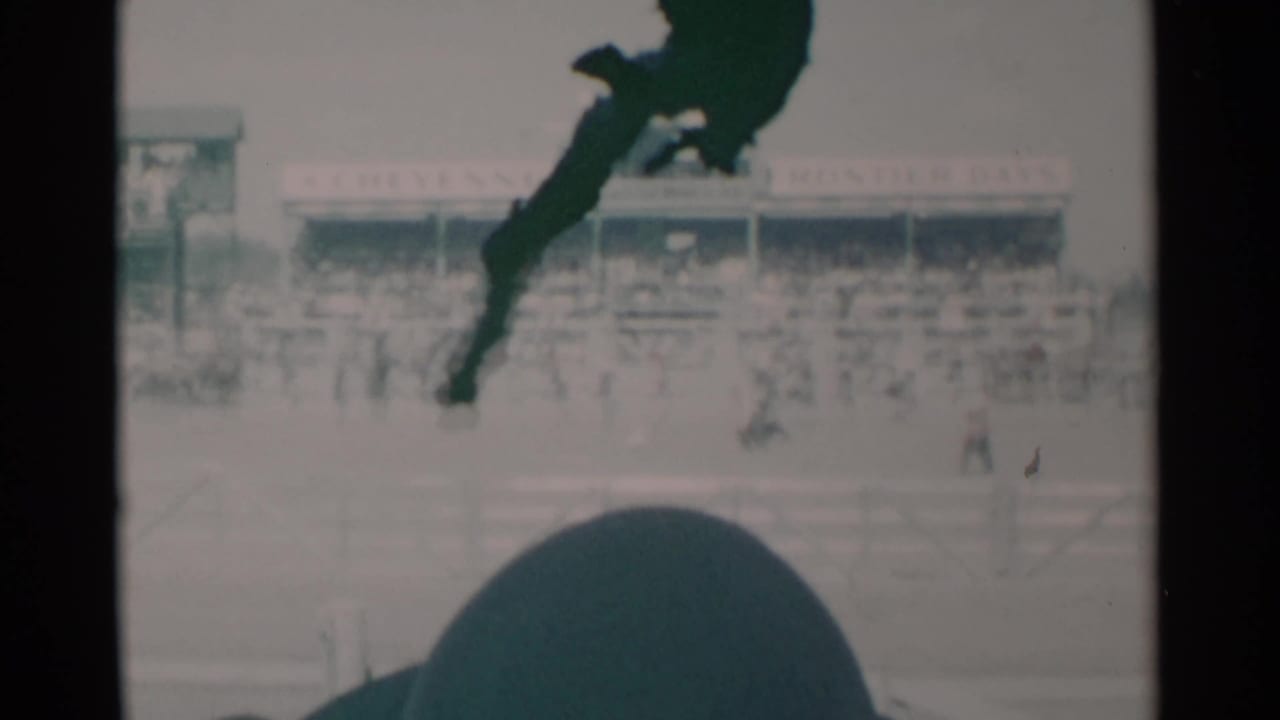 Grandstand and arena figures with a dark silhouette across the upper frame.