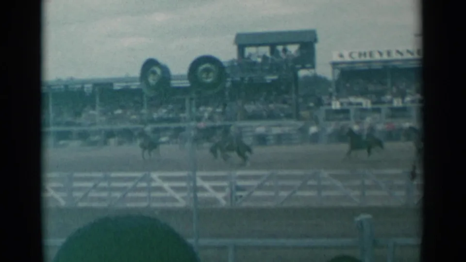 1961 Cheyenne Frontier Days arena view with multiple riders on horseback and spectators watching from elevated stands.