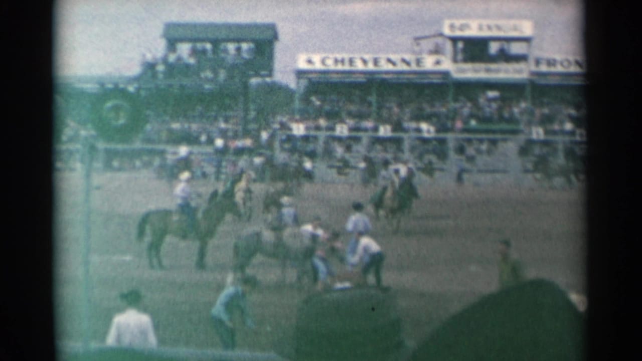 1961 Cheyenne rodeo scene with mounted cowboys, horses, arena workers, and a crowded grandstand under a Cheyenne sign.