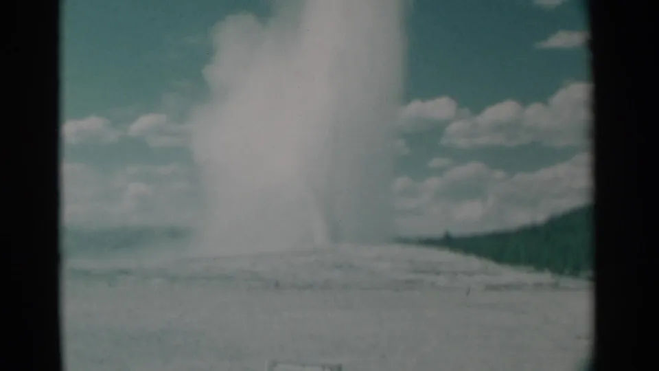 A wider lower view shows the geyser-like eruption rising from the ground with distant landscape and 8mm film texture.