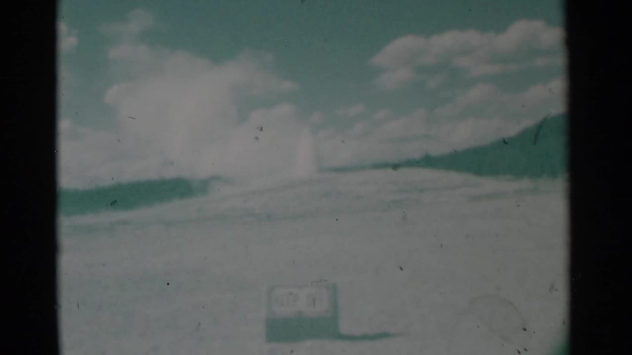 Faded outdoor horizon with cloudy sky and a faint bright plume in the distance.