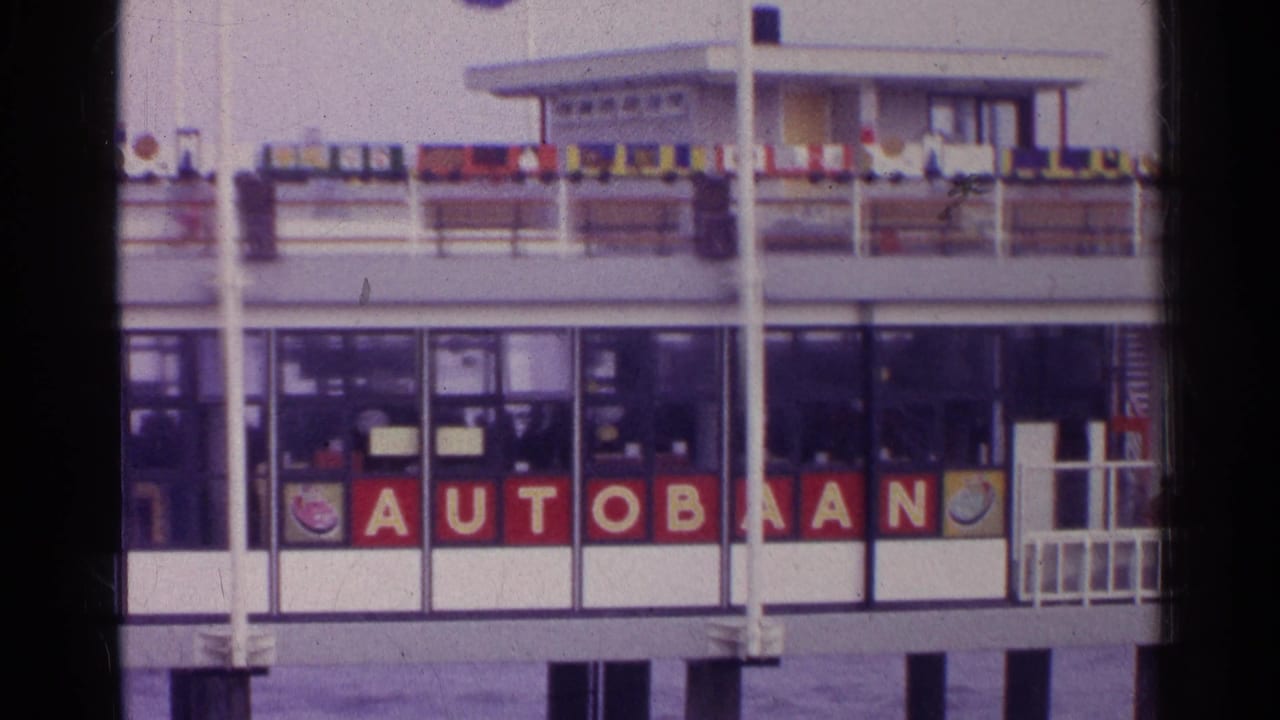 Ferry or terminal facade with AUTOBAAN letters, railings, windows, and flags above.