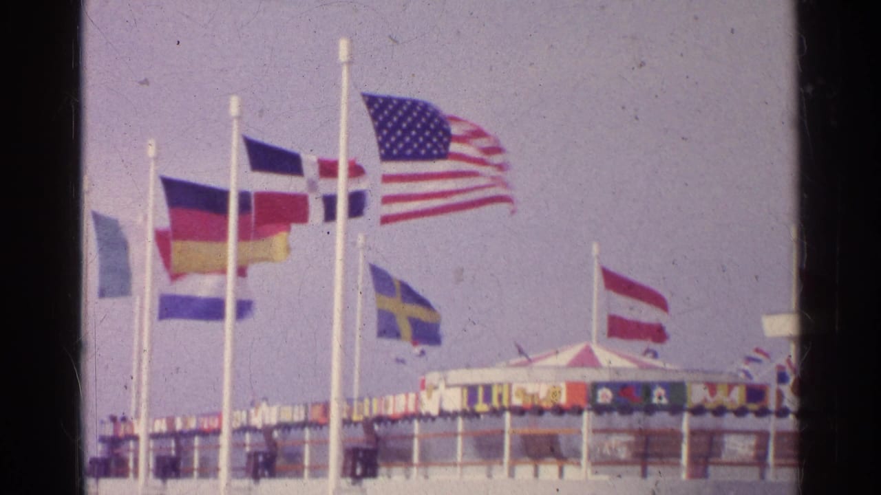 International flags waving near a public structure on a windy day.
