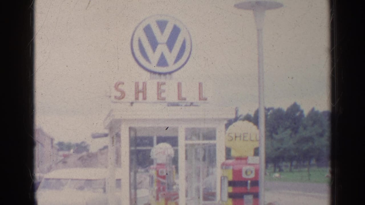 1961 Germany frame showing a Shell station front with a large Volkswagen logo above the building.