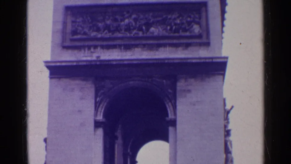1961 Paris 8mm frame showing the upper Arc de Triomphe, including the arch opening, carved frieze, stone ledge, and purple color cast.