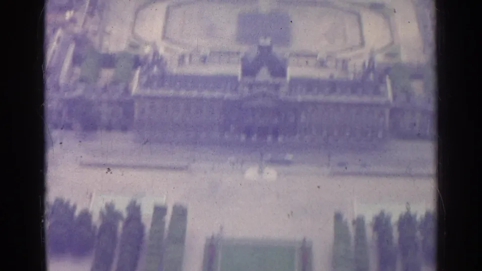1961 Paris 8mm frame showing the mansion facade area above formal gardens, with lawns and trees below.