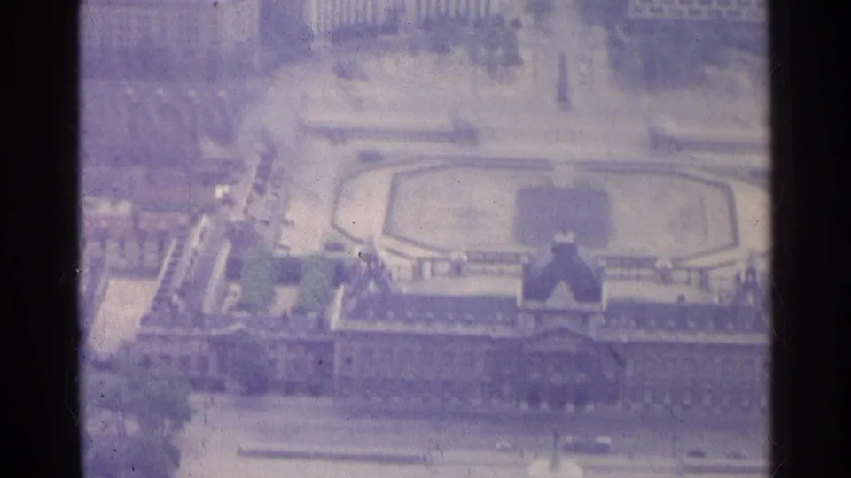 1961 Paris aerial frame with the formal garden centered below surrounding rooftops, roads, and a palace-like facade.