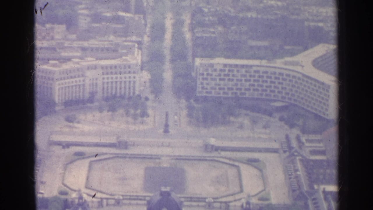 High aerial view of Paris buildings around a broad boulevard and central plaza.