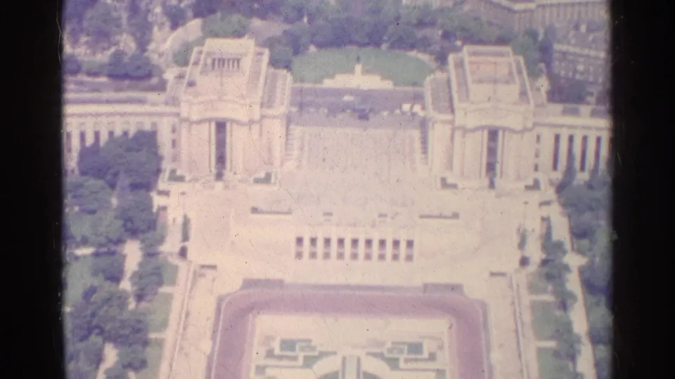 1961 Paris aerial frame showing monumental architecture, a broad pale plaza, green lawns, and a formal garden axis.