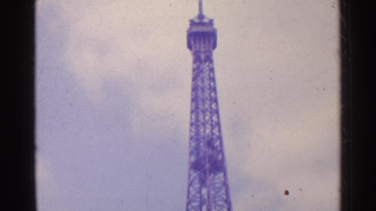 Low-angle view of the Eiffel Tower against a cloudy sky.