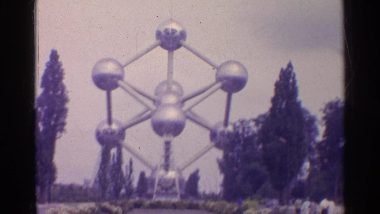 Large interconnected metal spheres framed by trees and a pale sky.