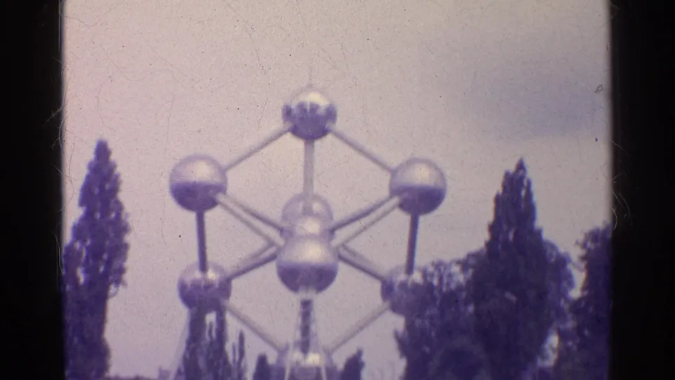 Soft 8mm frame showing the silver sphere-and-rod structure from below, with trees along the sides.