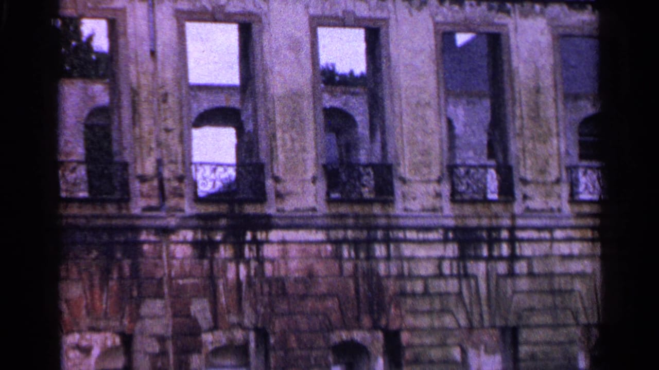Upper stories of an ornate building facade with balconies and tall windows.