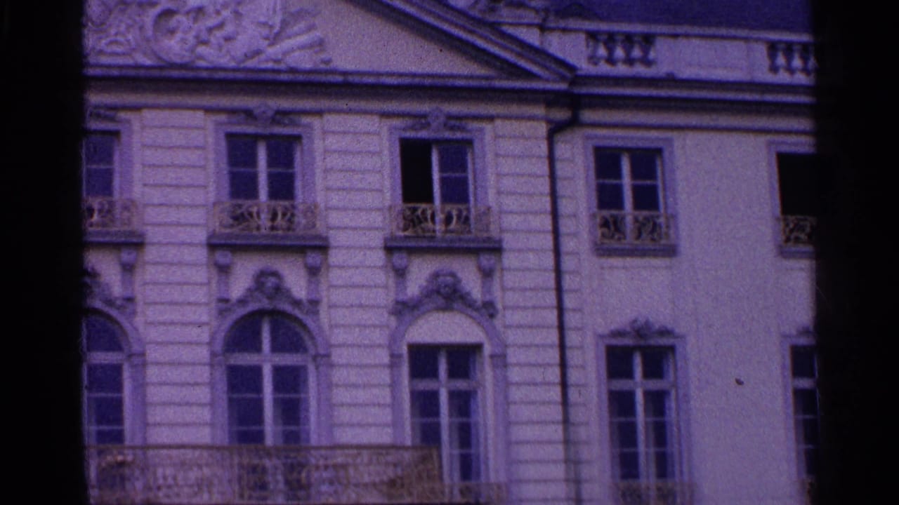 1961 Swiss 8mm frame showing lower architectural details, including arched windows, carved trim, and a balcony edge.