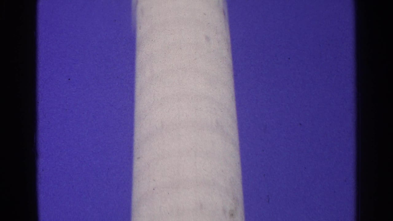 1961 Switzerland 8mm still showing the pale cylindrical form continuing through the frame with blue sky and archival film marks.