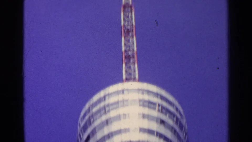 1961 Swiss 8mm frame showing the tower's round deck with a tall antenna mast extending upward.