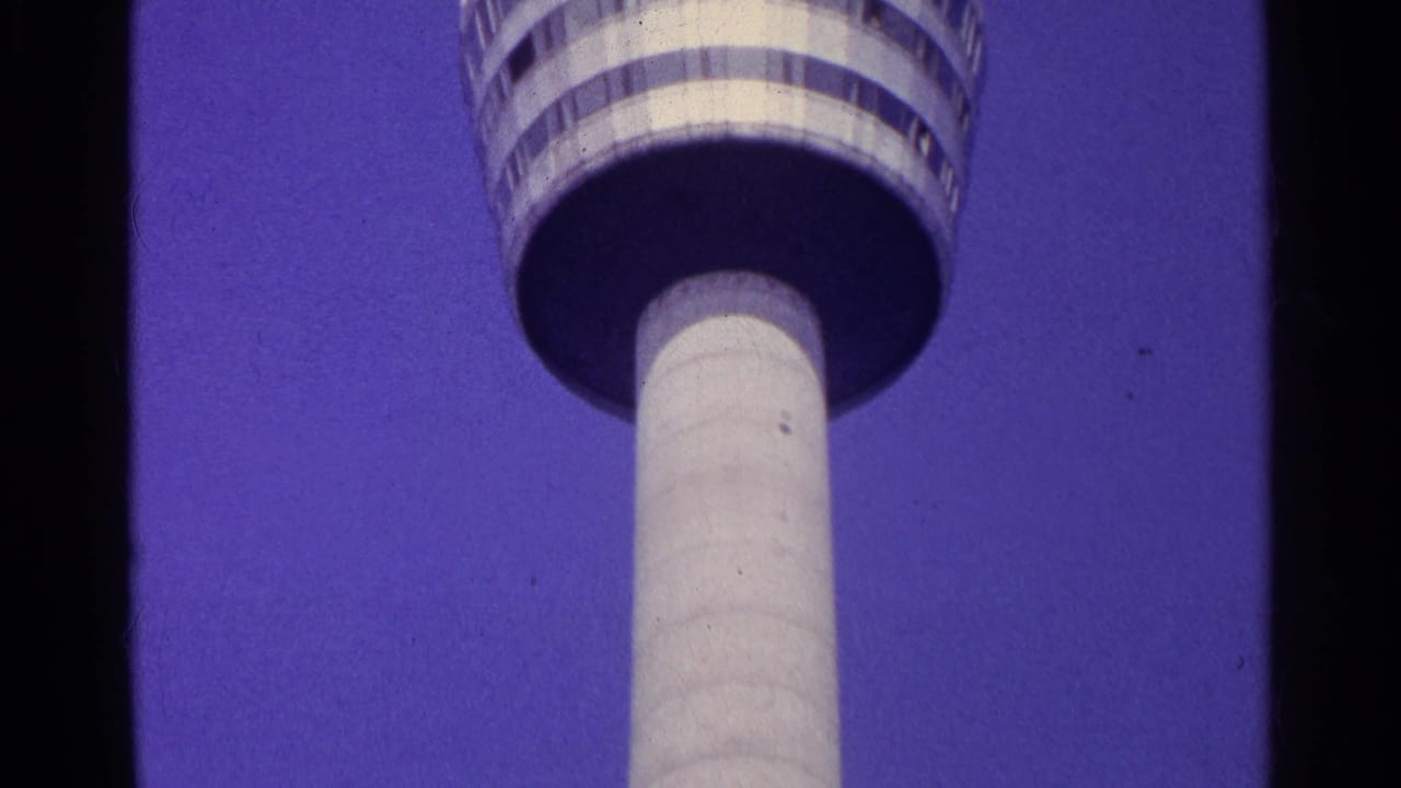Closer low-angle view of the tower deck and white shaft against blue sky.