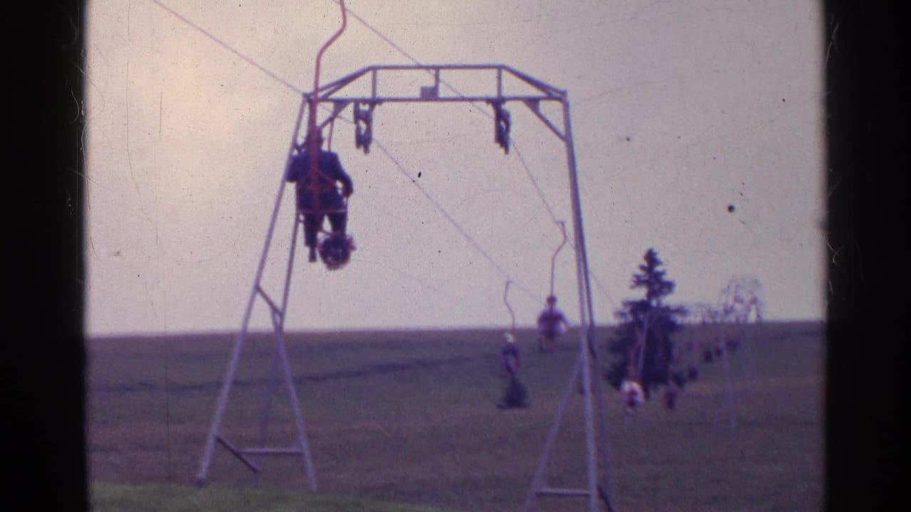 Small chairlift carrying riders over a grassy hillside.